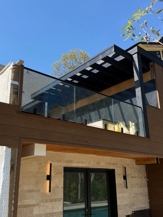 This grilling deck is laminated glass with a top rail and spigots for support and safety while still maintaining a frameless look!